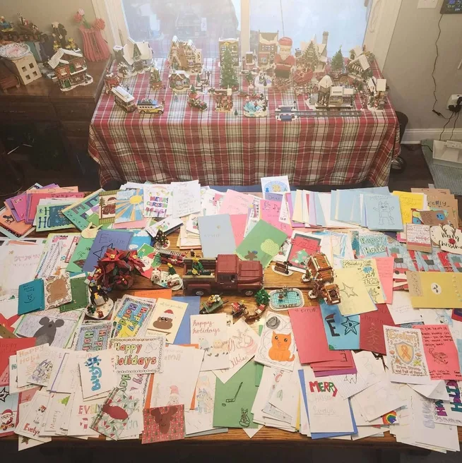 Hundreds of handmade cards covering a table and the floor