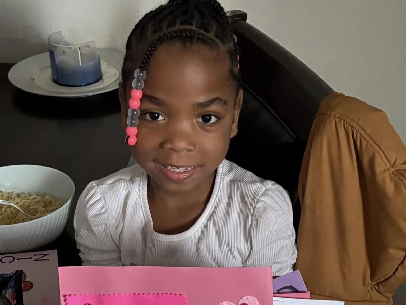 A girl holding a pink handmade valentine card